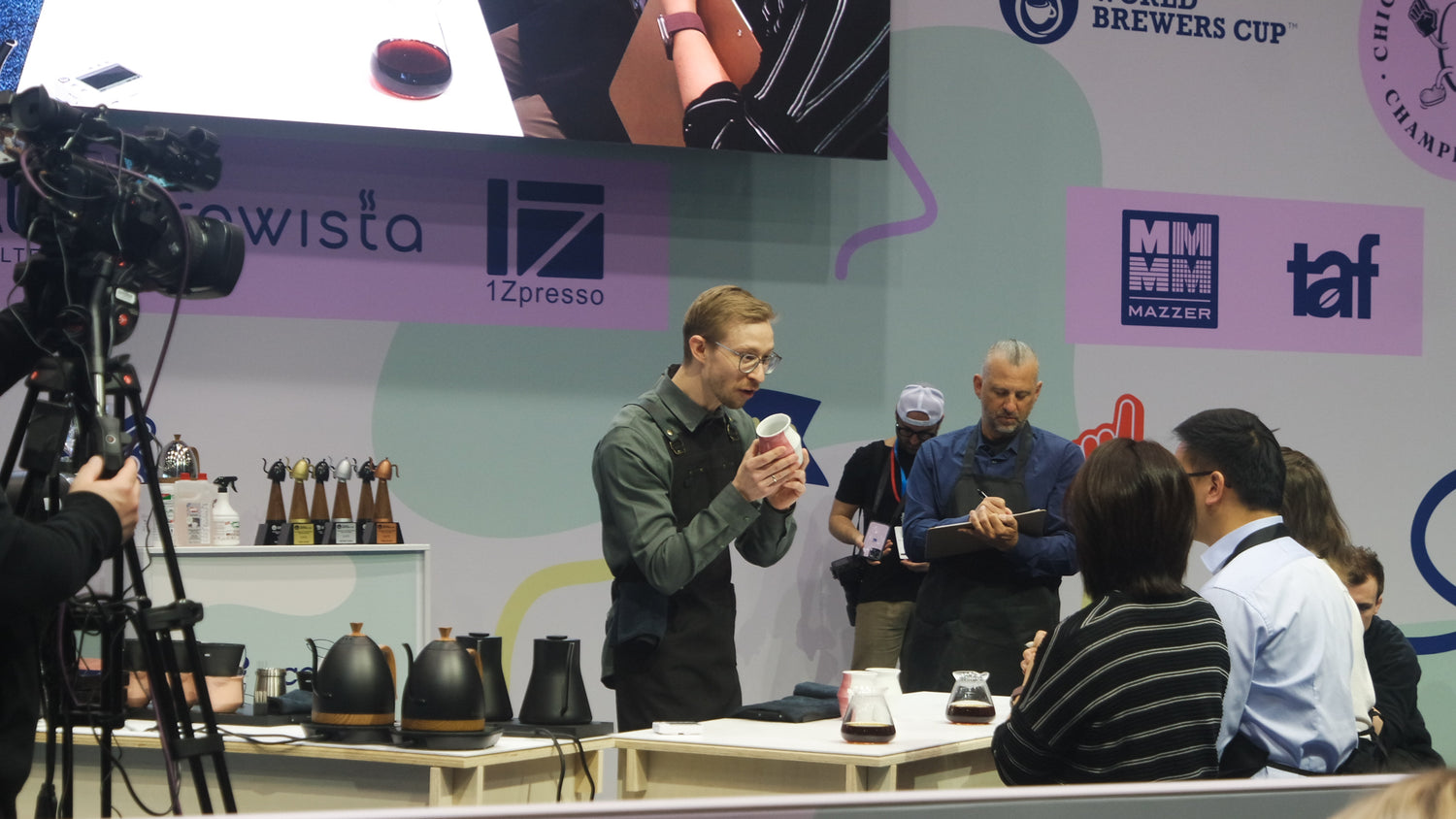 Person zeigt einer Jury 2-waycup-Tasse