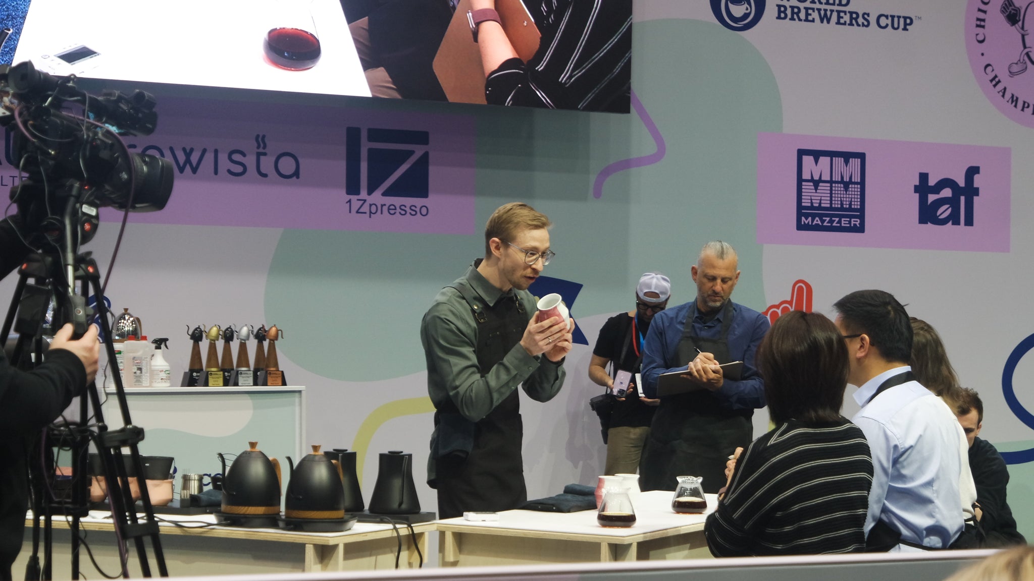 Person zeigt einer Jury 2-waycup-Tasse