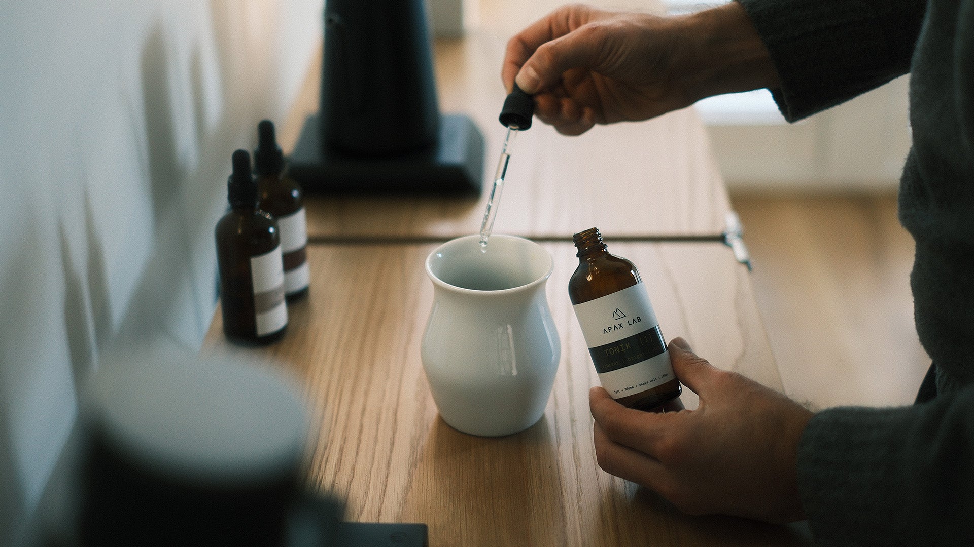 jemand tropft Mineralkonzentrat mit Pipette in Kaffeetasse