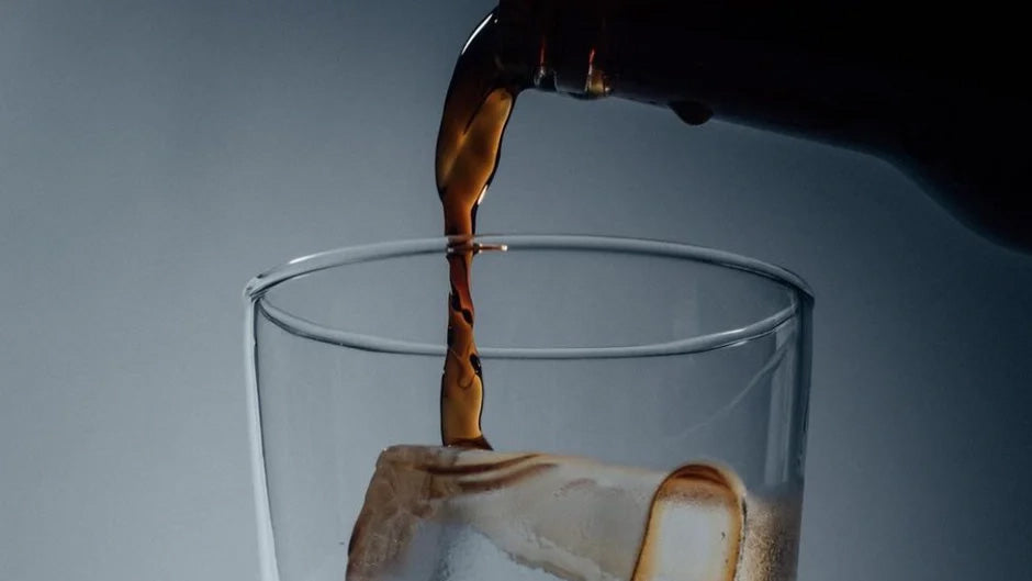 Cold Brew wird über Eiswürfel in einem Glas gegossen