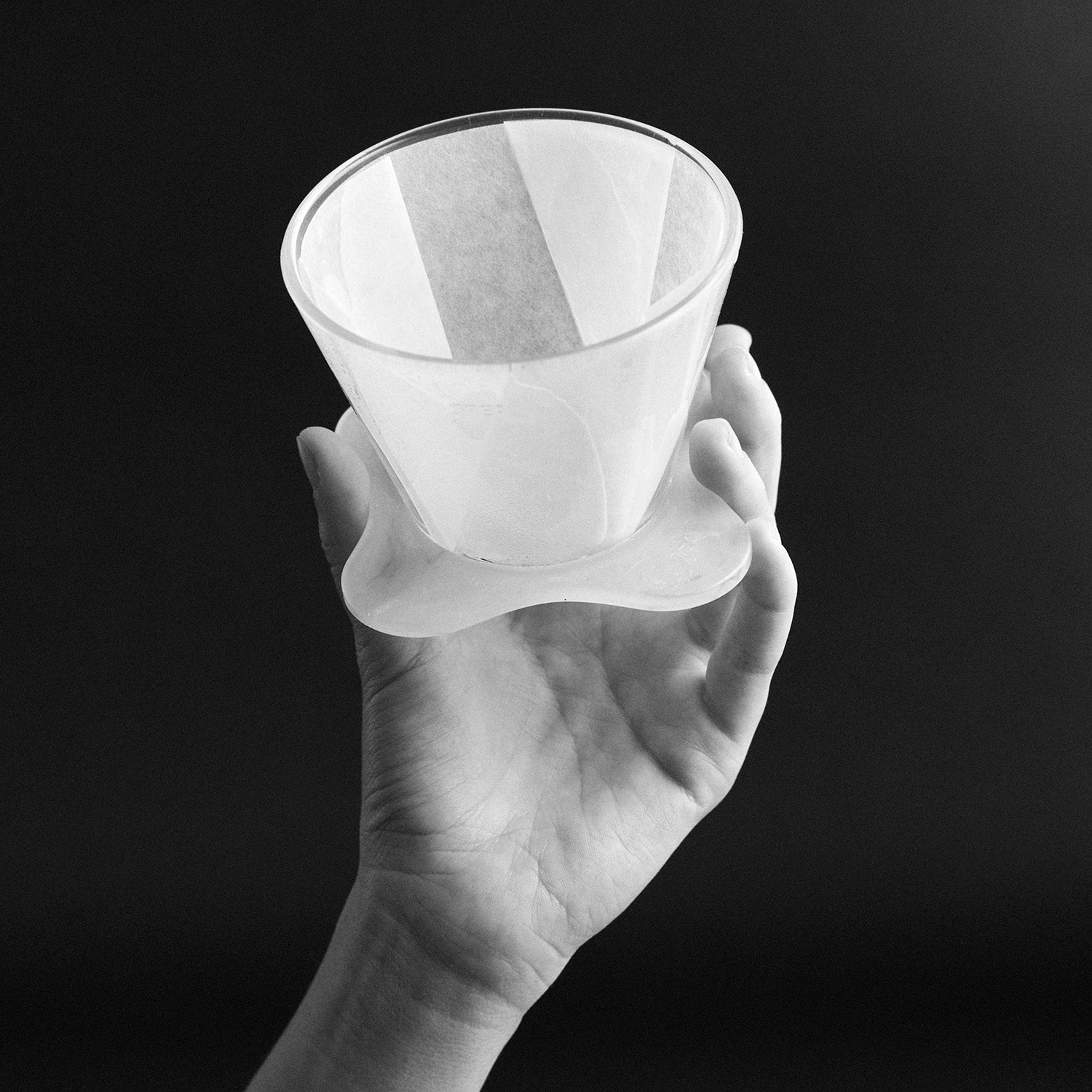Hand hält Orea-Dripper mti Filterpapier nach oben