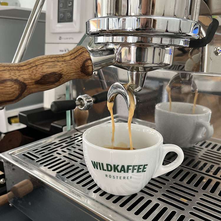Doppelter Espresso läuft aus Siebträgermaschine in Wildkaffee-Tasse