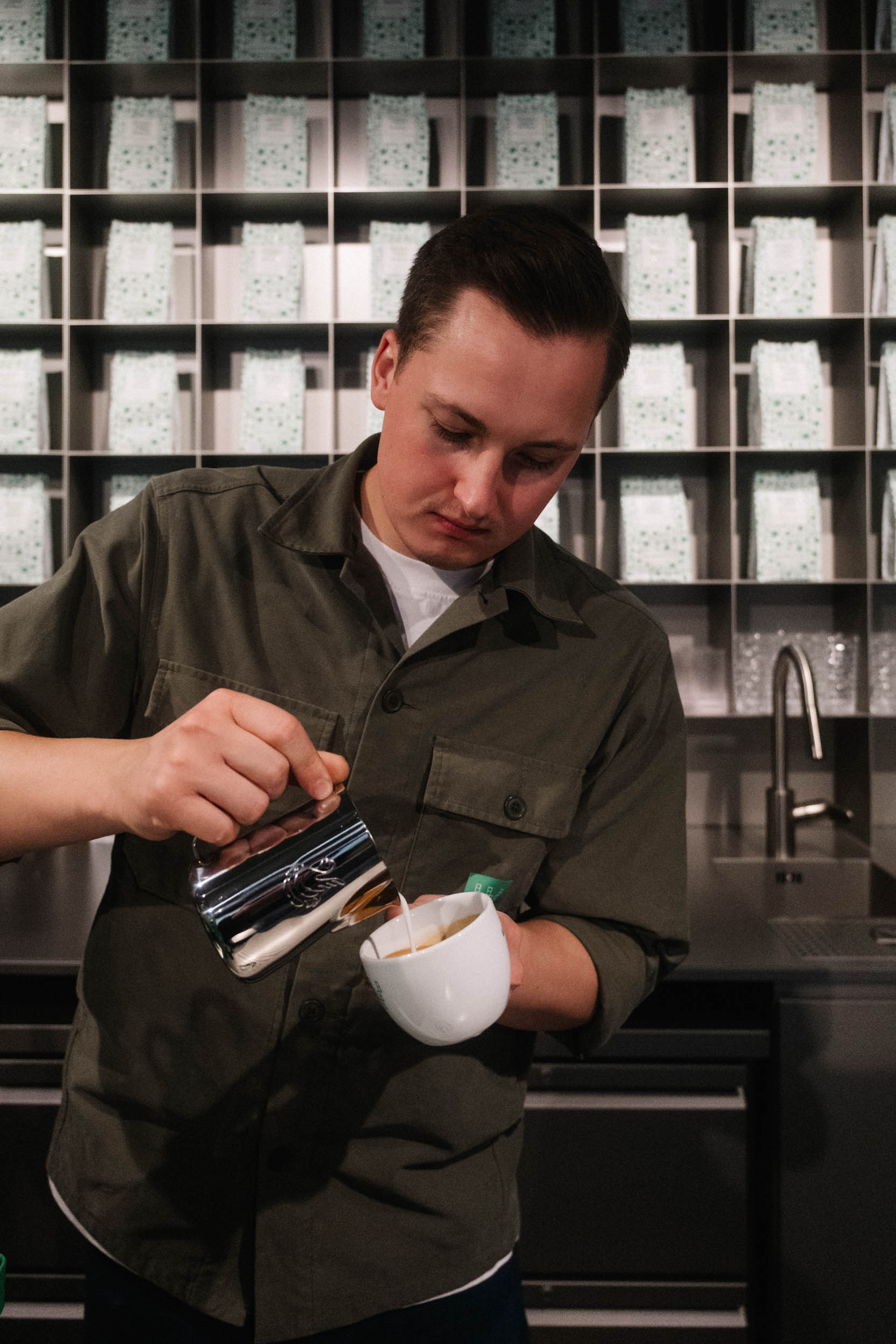 Barista gießt Latte Art in einen Cappuccino