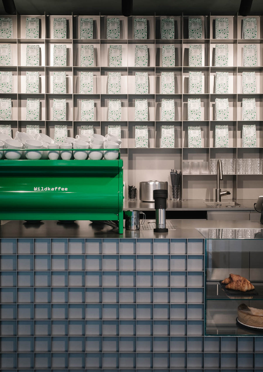 Tresen mit Siebträgermaschine und Kaffeepackungen im Hintergrund