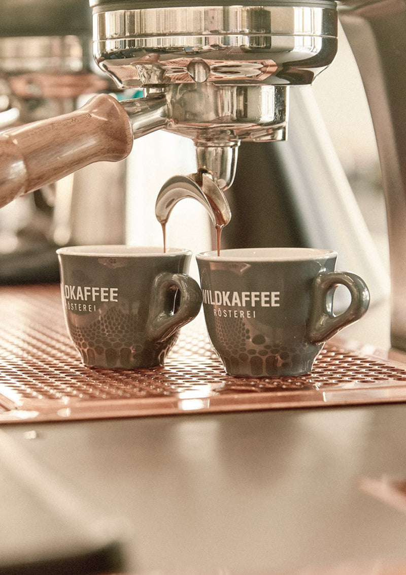 zwei Espressotassen unter Siebträger, Espresso läuft raus