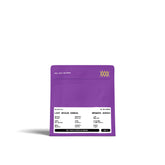 Lila Kaffeetüte mit weißem Etikett mit Text