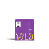 Lila Kaffeetüte mit weißem Etikett mit Text