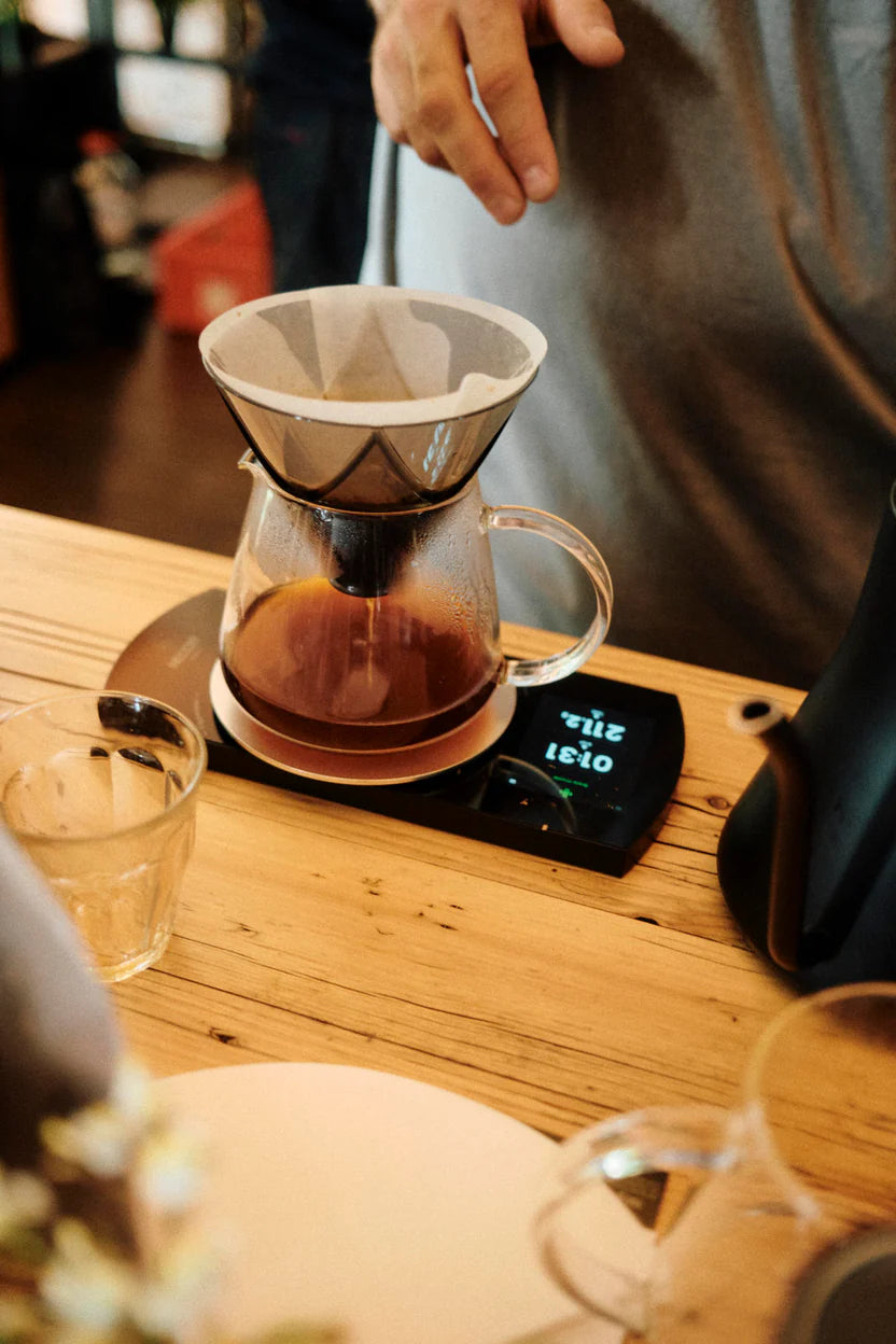 Waage mit Kanne und Kaffeefilter in Brew Bar