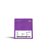 Lila Kaffeetüte mit weißem Etikett mit Text