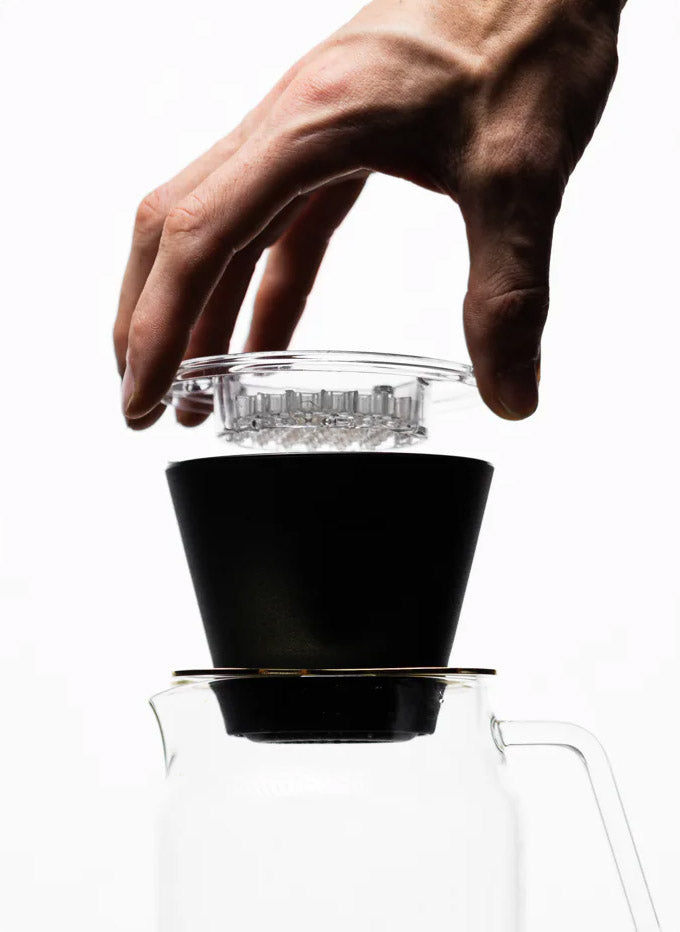 Hand hält Melodrip über schwarzen Dripper