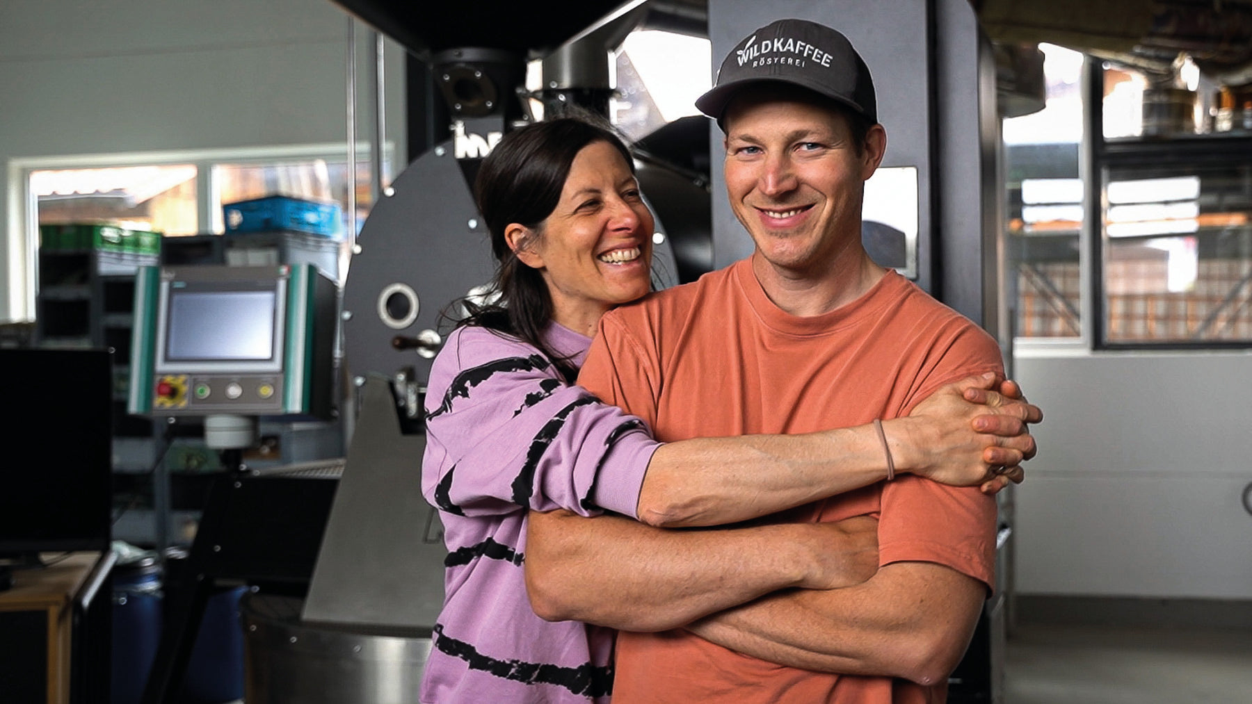 lachendes Pärchen, Frau und Mann, vor Röstereihintergrund