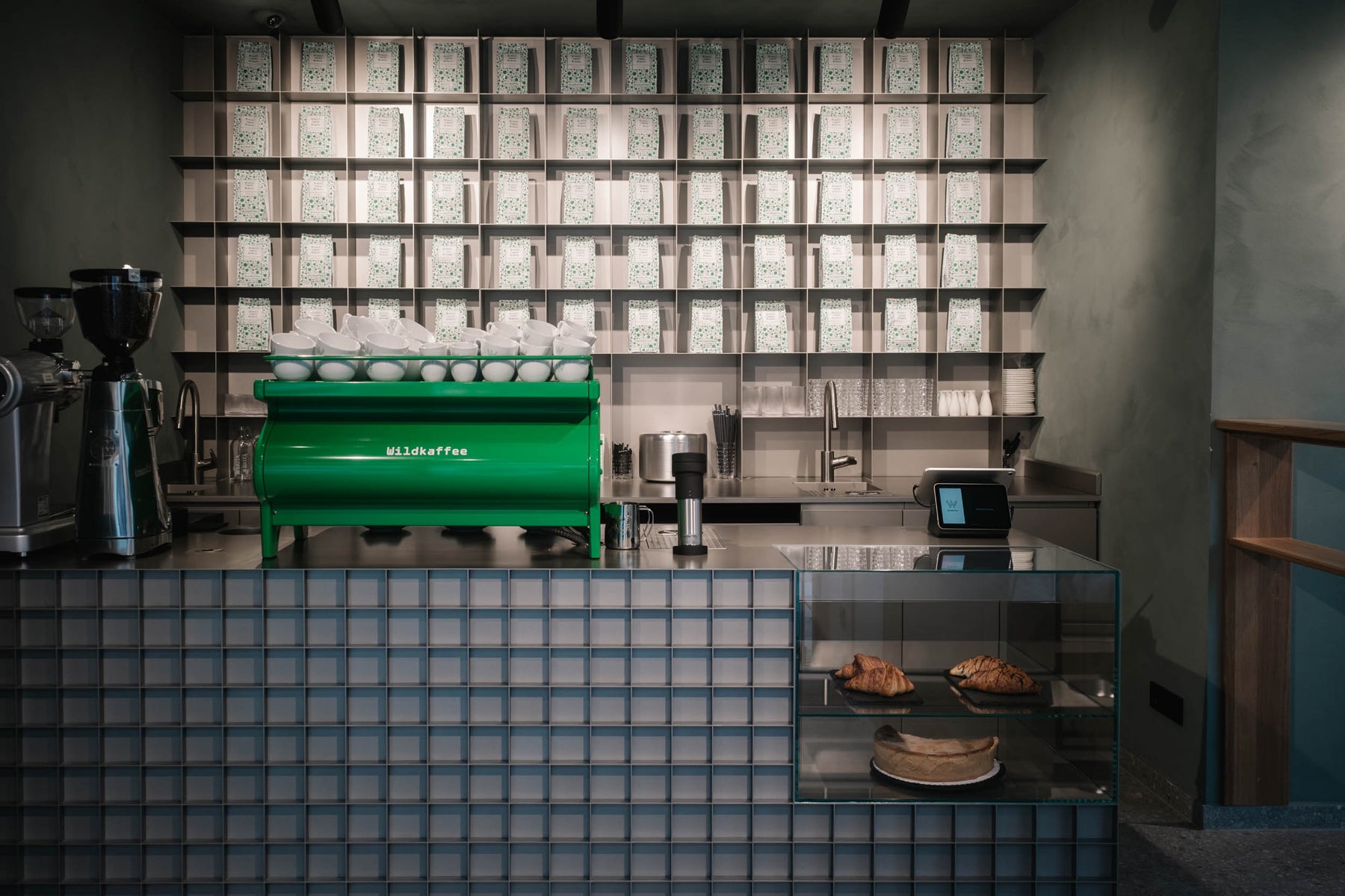 Bar-Tresen mit Kaffeemühle, Siebträgermaschine und Kuchen in Glasvitrine